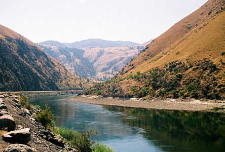 [The river rounds a bend out of sight to the right. The roadway is beside the river, but other than the river and the road, there is nothing but tall hillsides.]